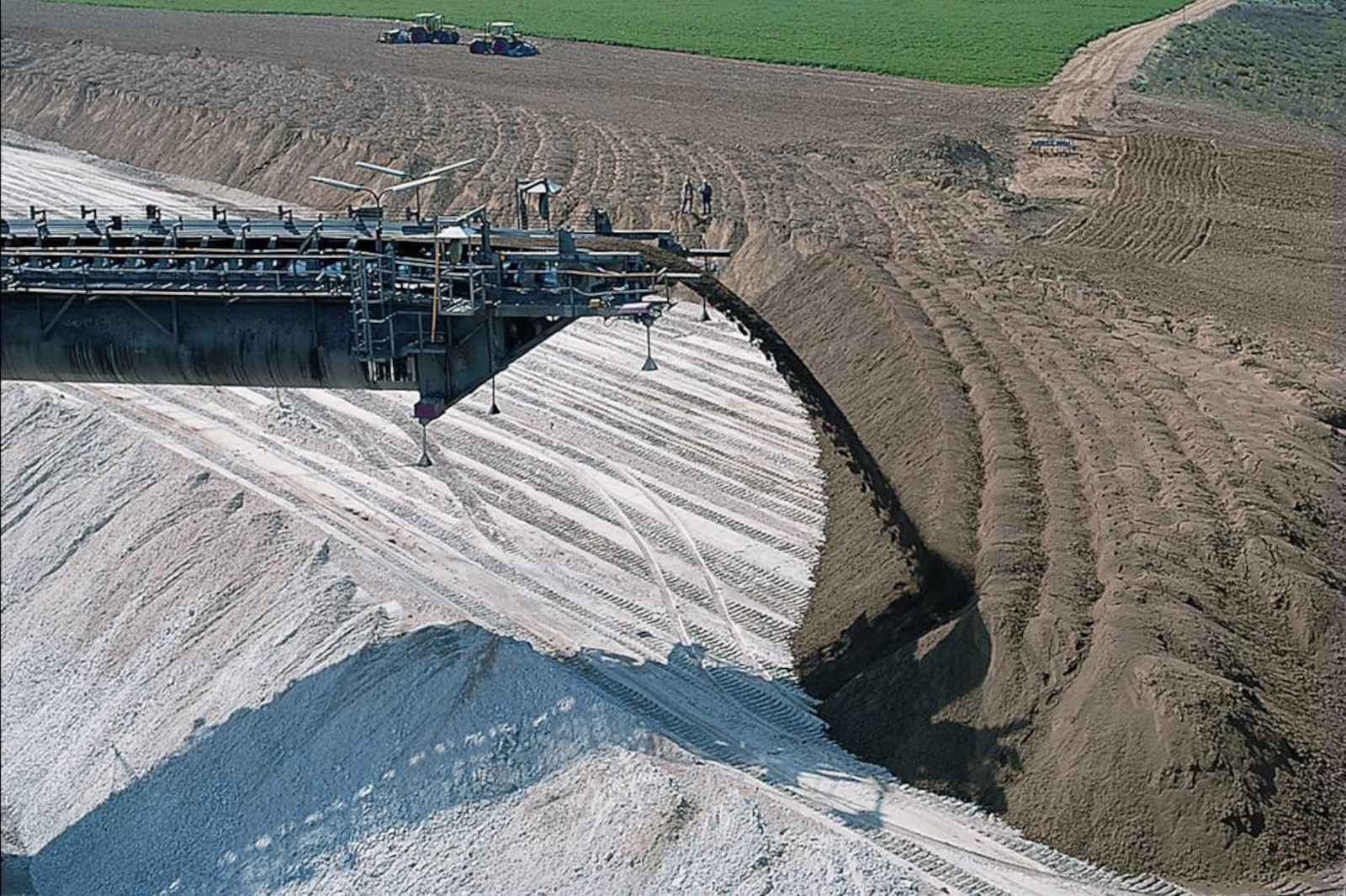 Eine Luftaufnahme einer großen Baustelle mit Maschinen und Erdhaufen, die die Aushubprozesse demonstriert.